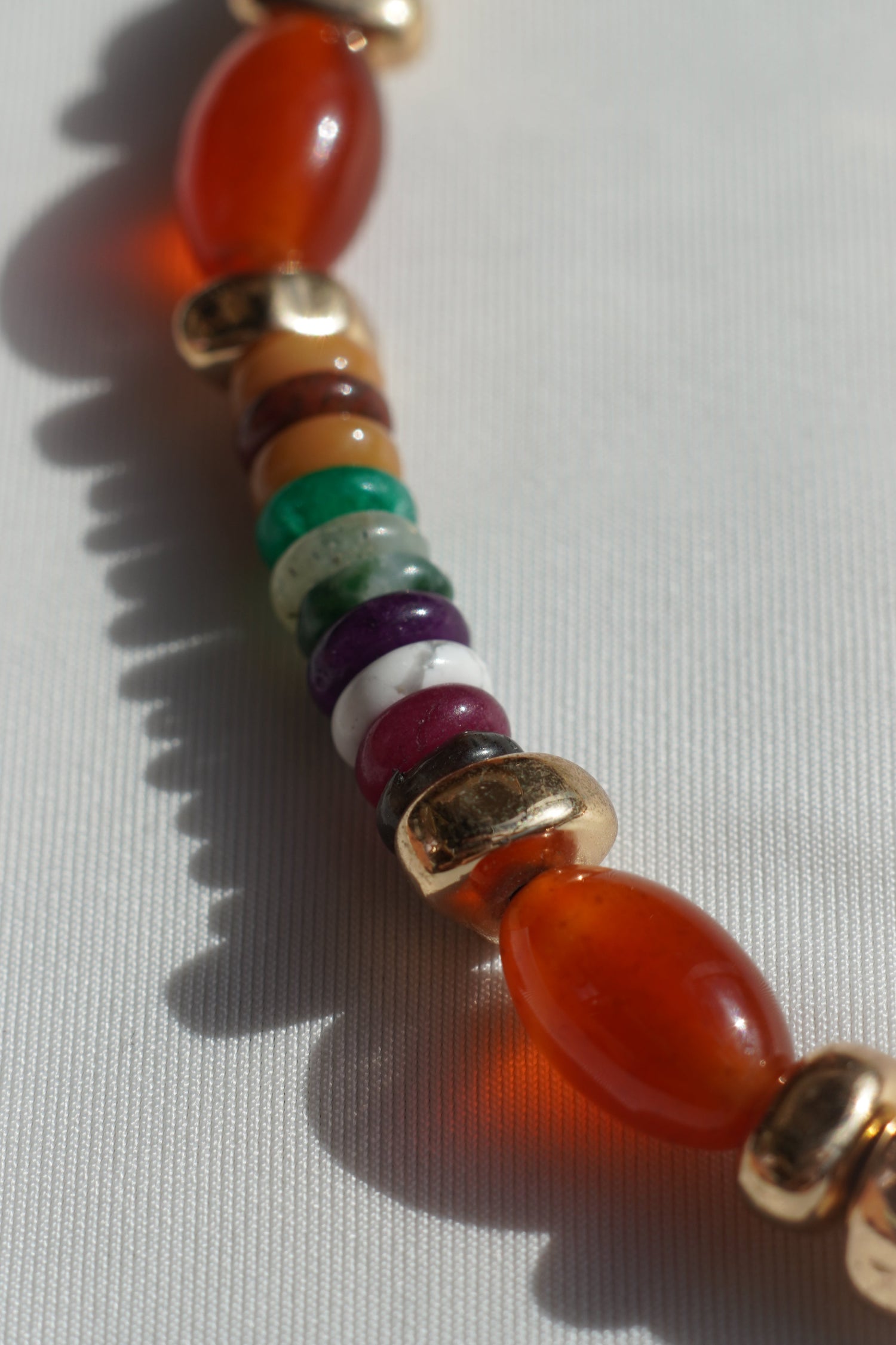 Close-up of a beaded bracelet with gold accents on a white background